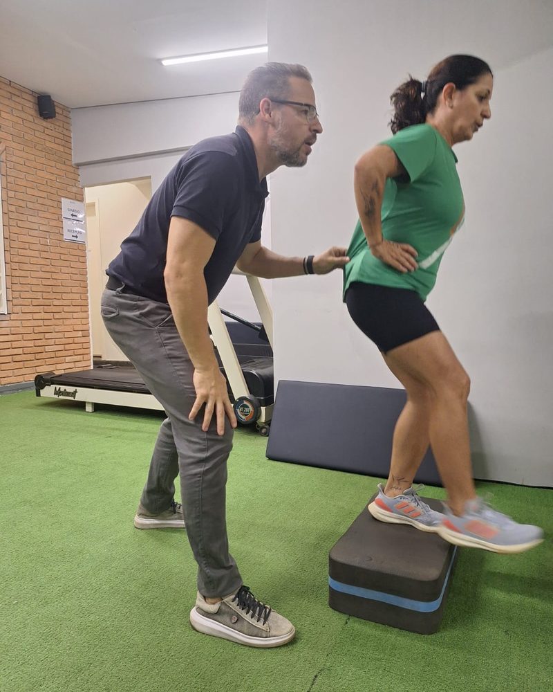 Dr. Osvaldo orientando paciente em exercício funcional de step na Clínica NIS